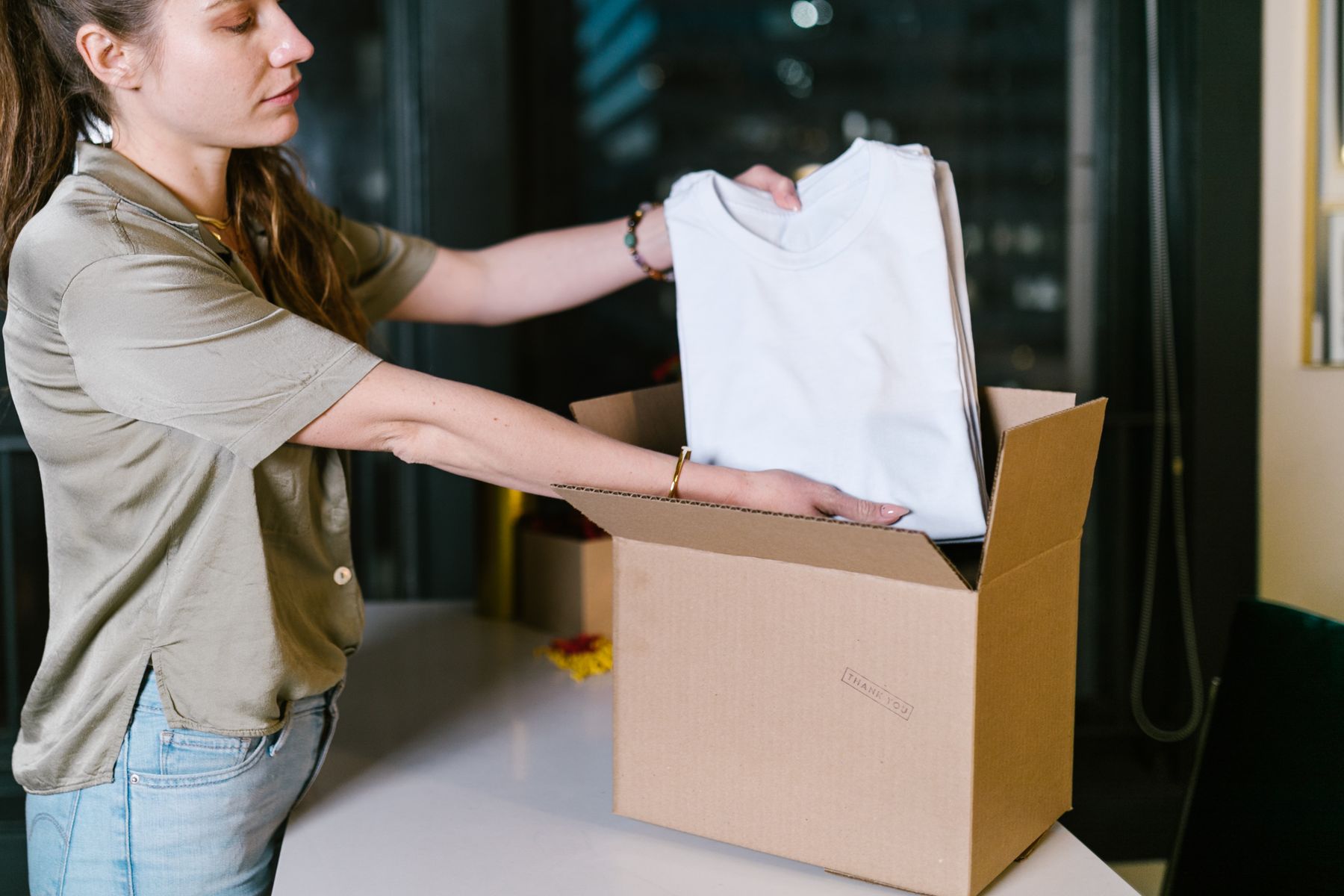 Clothing carefully placed into a cardboard shipping box