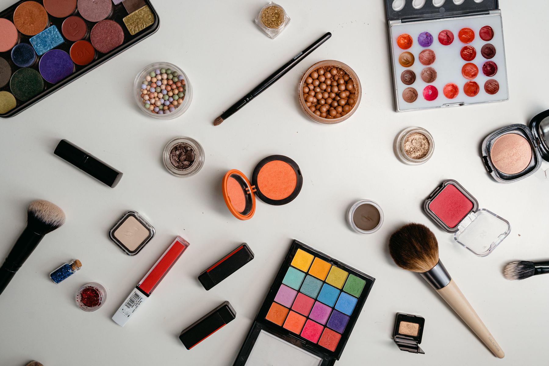 An assortment of small beauty and personal-care products on a light surface